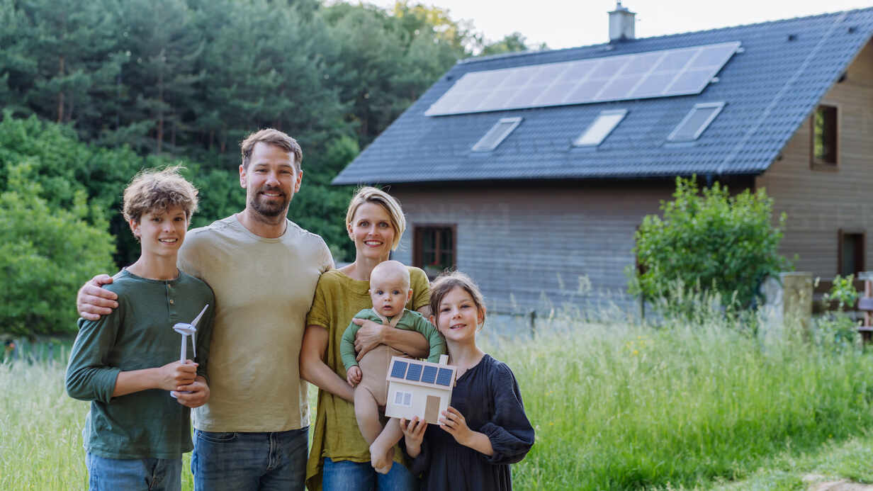 Glückliche Familie mit Solaranlage für nachhaltiges Leben